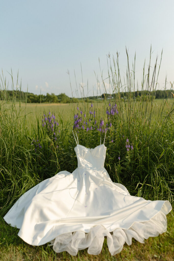 A serene bride, Ella, standing barefoot in a meadow with wildflowers, embodying tips and inspiration to transform your elopement morning into a magical, intentional experience.