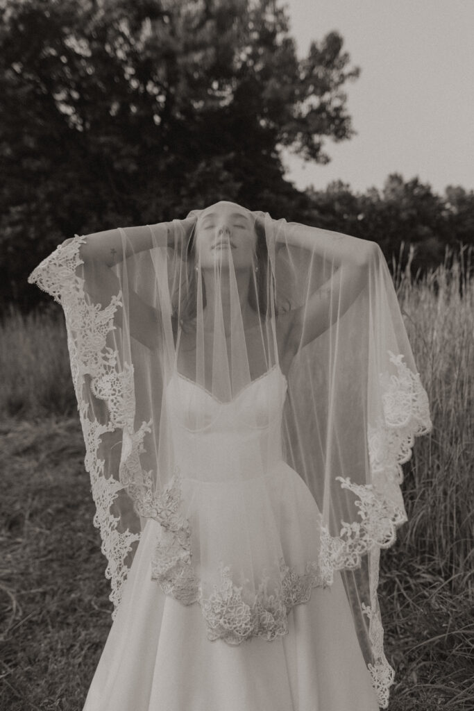 A serene bride, Ella, standing barefoot in a meadow with wildflowers, embodying tips and inspiration to transform your elopement morning into a magical, intentional experience.