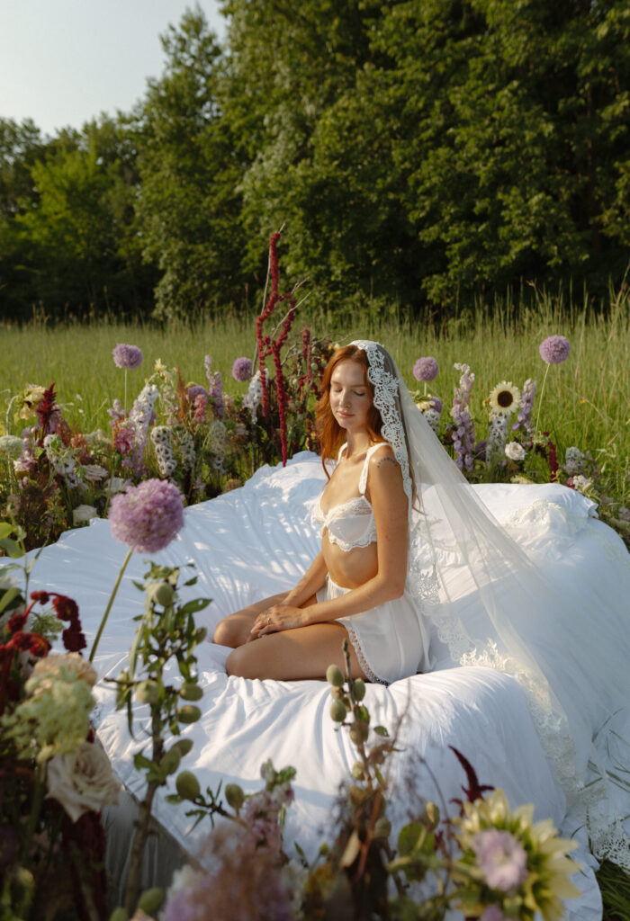 A serene bride, Ella, standing barefoot in a meadow with wildflowers, embodying tips and inspiration to transform your elopement morning into a magical, intentional experience.