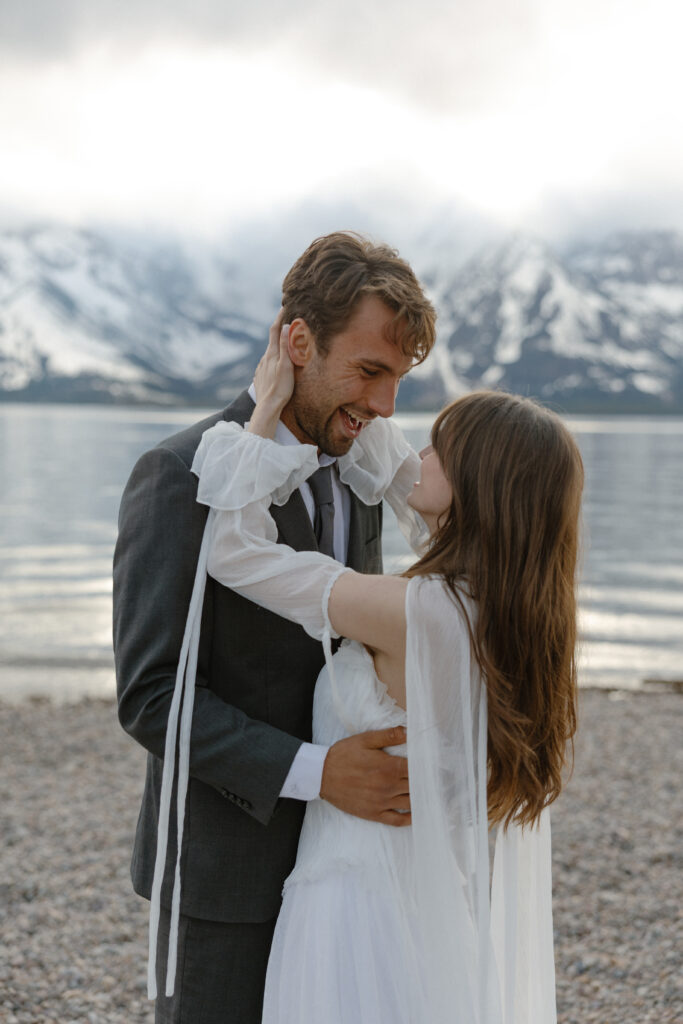 Bride and groom embracing during a moody Colter Bay elopement in Grand Teton National Park