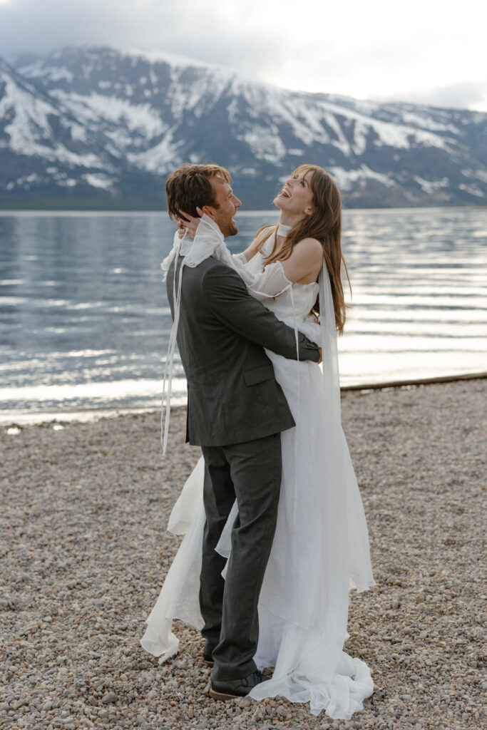 Bride and groom embracing during a moody Colter Bay elopement in Grand Teton National Park