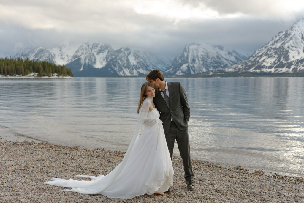 Bride and groom embracing during a moody Colter Bay elopement in Grand Teton National Park