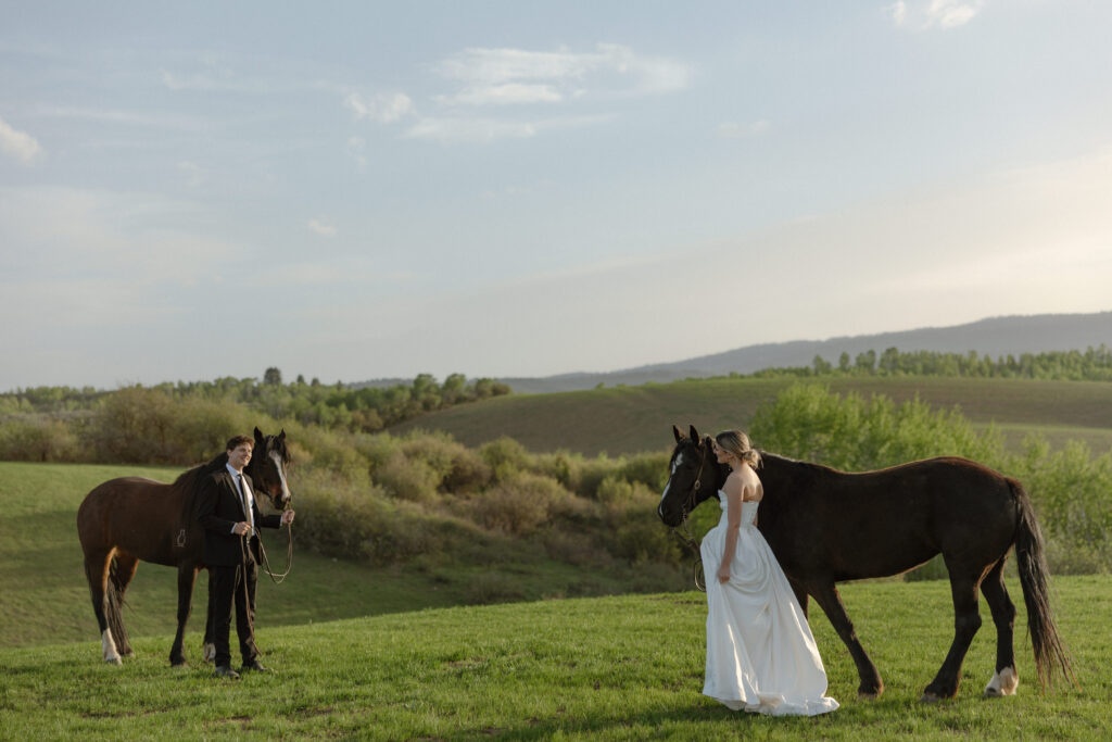 Bride and groom walking through open pasture during a luxurious Wyoming horse elopement at Heiner Ranch near Jackson Hole