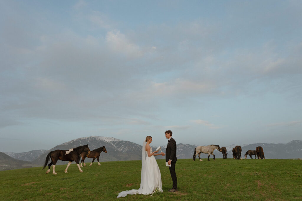 Bride and groom walking through open pasture during a luxurious Wyoming horse elopement at Heiner Ranch near Jackson Hole