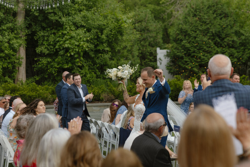 Newlyweds walking down the aisle at their Hutton House wedding