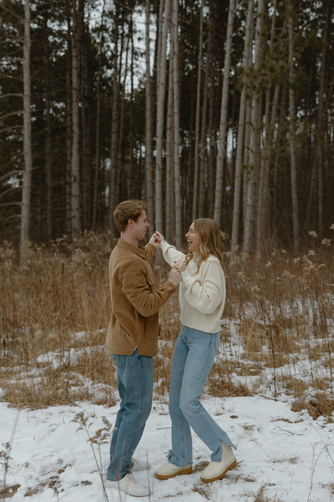 Couple laughing together during winter engagement photos at Rice Creek Regional Park