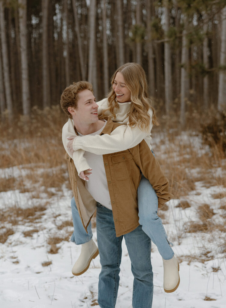Couple laughing together during winter engagement photos at Rice Creek Regional Park