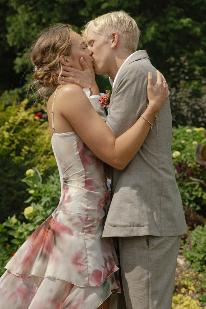 Bride and groom sharing their first kiss at their intimate Lyndale Rose Garden elopement